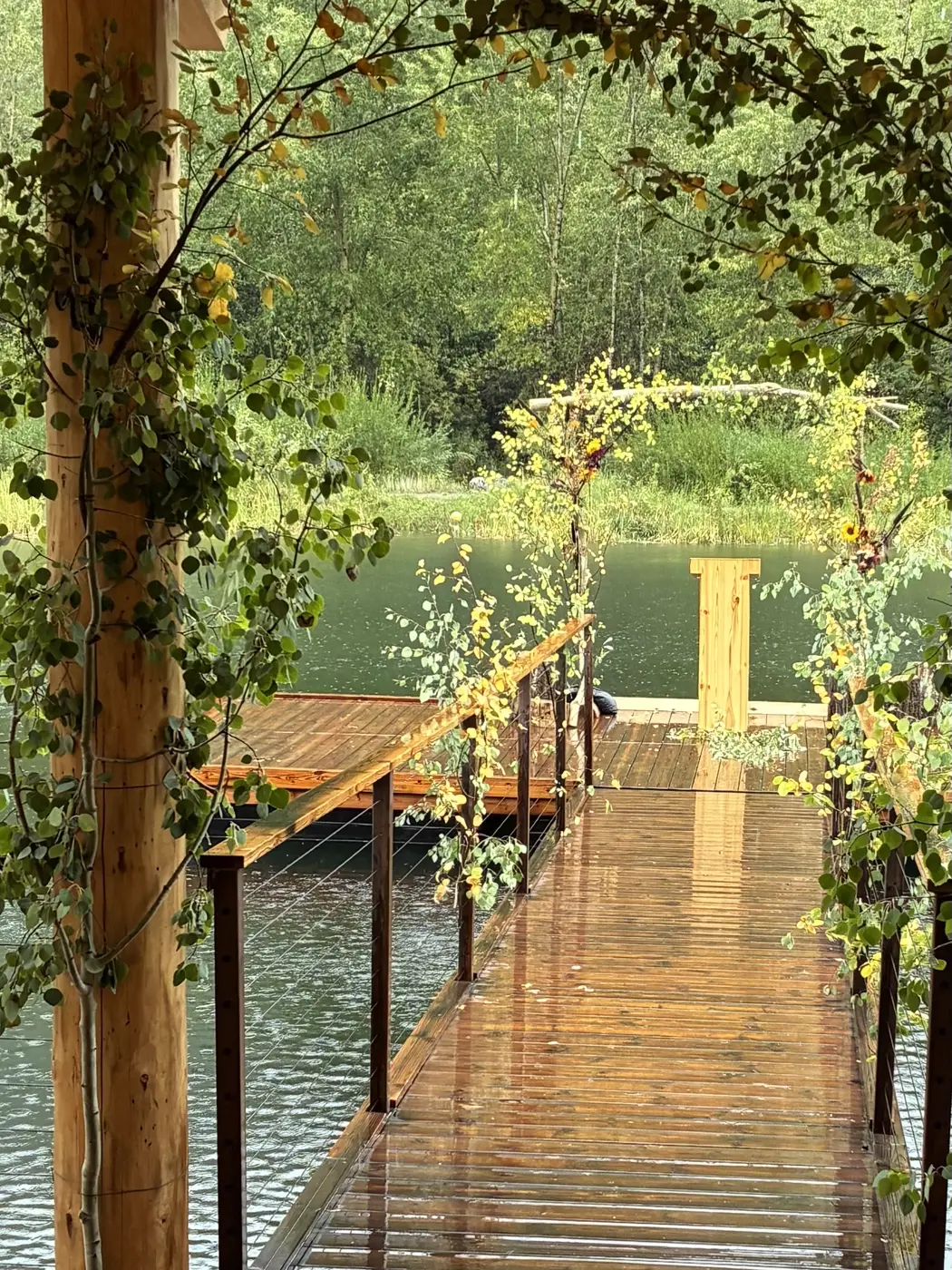 A dock over still water dressed with floral arches for a ceremony